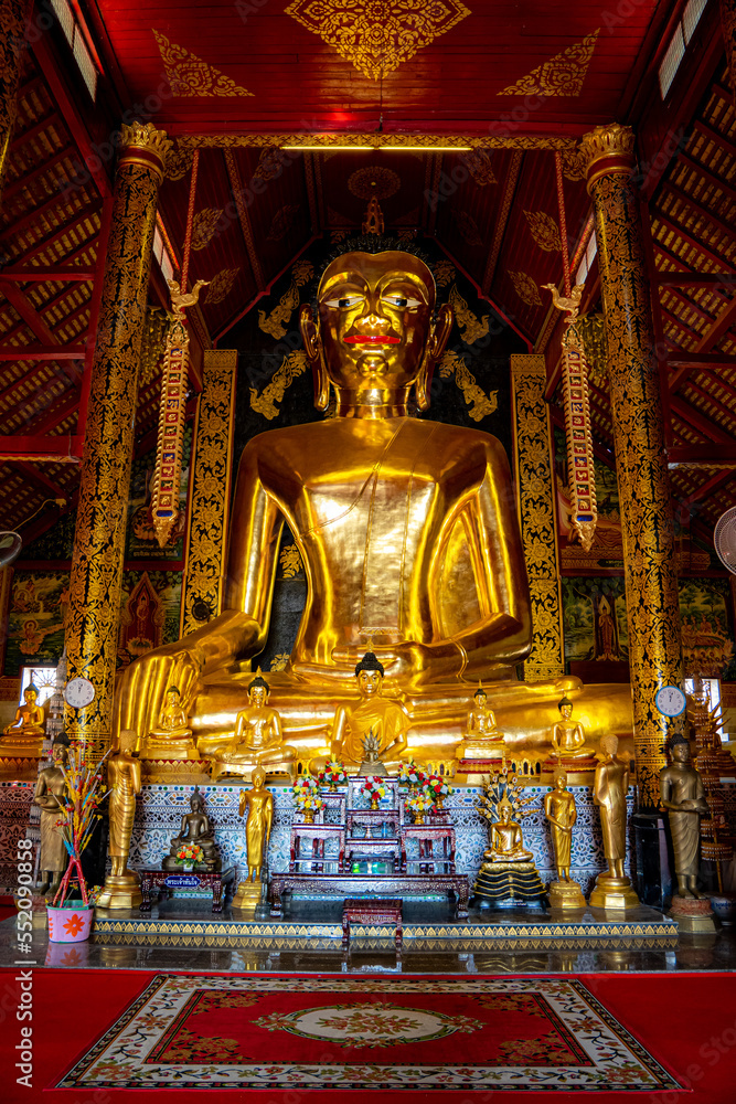 Goldener glänzender überdimensionaler sitzender Buddha welcher in einem thailändischen Tempel ist, in Chiang Rai, Nordthailand, Asien