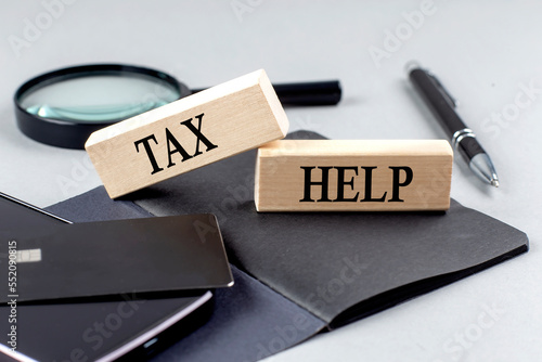 TAX HELP text on wooden block on black notebook , business concept