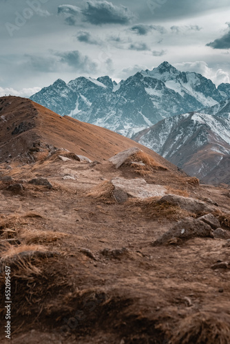 Mountains landscape with some people hiking. Sunset or sunrise in mountains. 