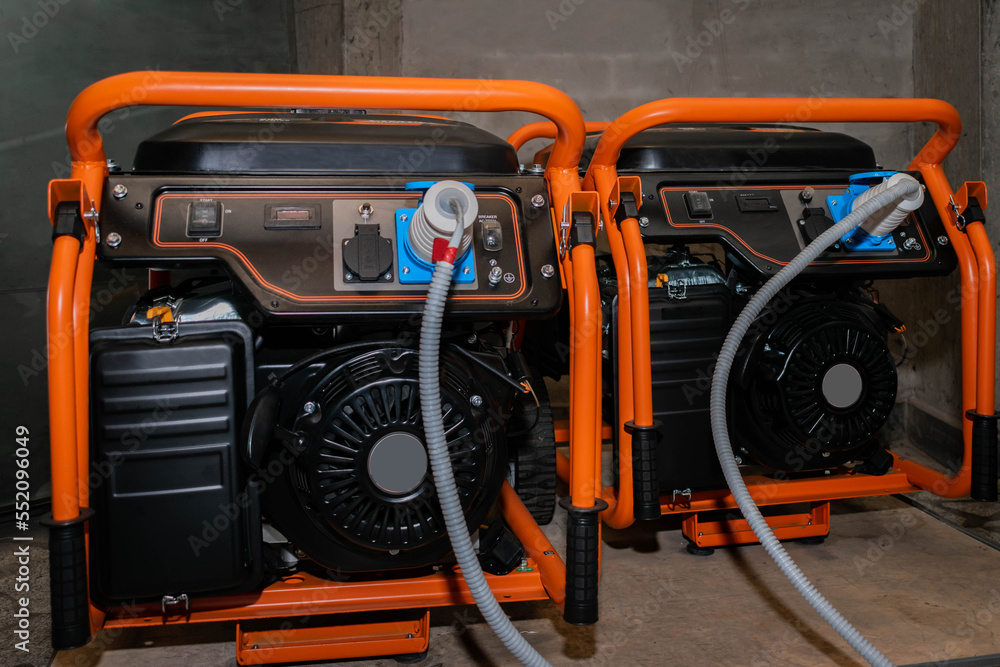 Fototapeta premium Two gasoline generators generate electricity during the blackout. Powerful electric generators work in the garage.