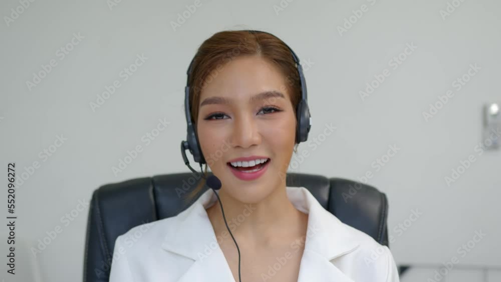 Asian call center woman, customer service, wearing headset or headphone talking with customer in in a call centre office. Asian call center woman, customer service, wearing headset or headphone talking with customer in in a call centre office.
