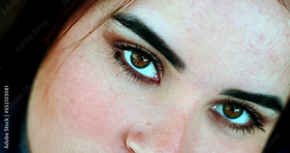 Naklejka premium Young woman eyes staring at camera, macro close-up face