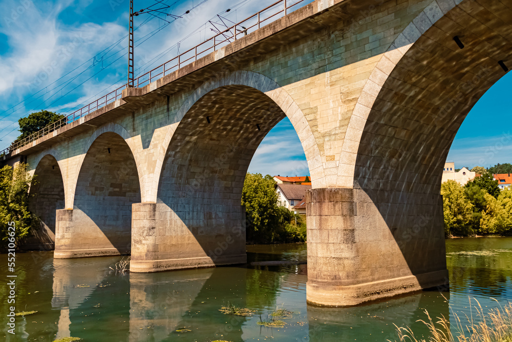 Fototapeta premium Beautiful summer view with reflections, an ancient bridge and a church at Vilshofen, Danube, Bavaria, Germany