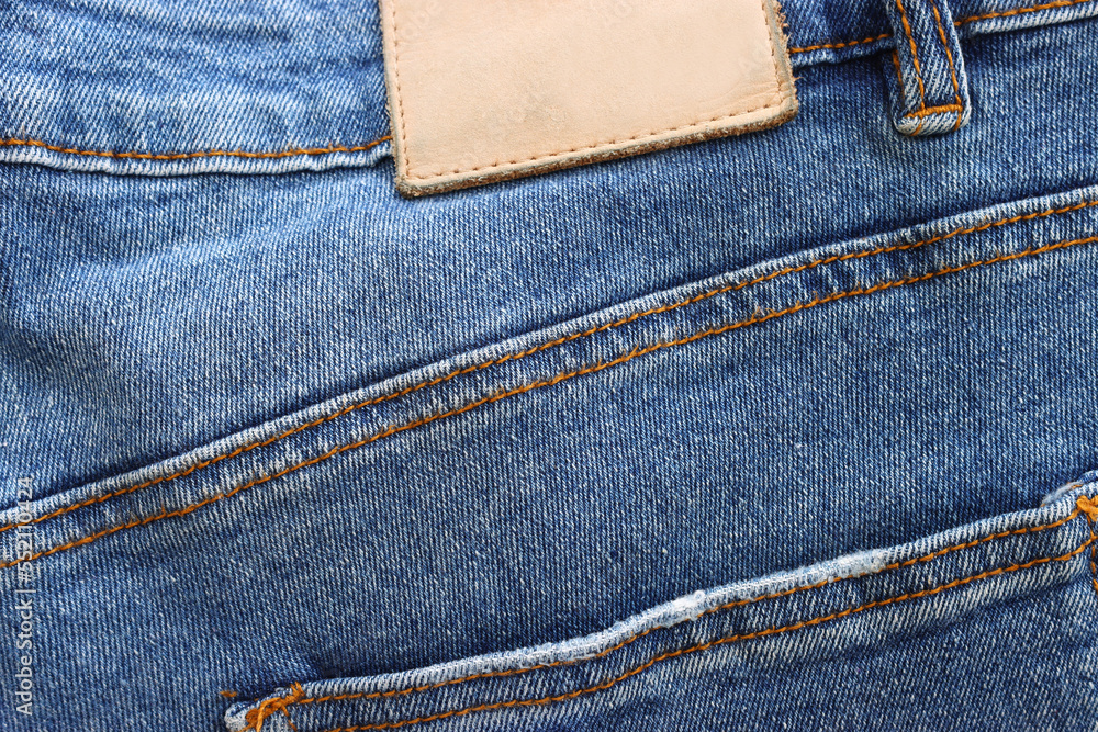 close up of worn blue jeans cloth fabric with empty label