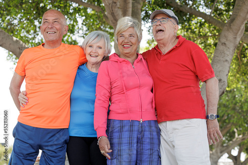 gruppo di 4 amici anziani vestiti con abiti sportivi si si diverte al parco