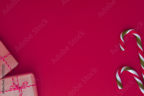 Christmas, winter holidays background. Wrapped Xmas gift boxes and candy canes on viva magenta color background. Top view, flat lay, copy space for text