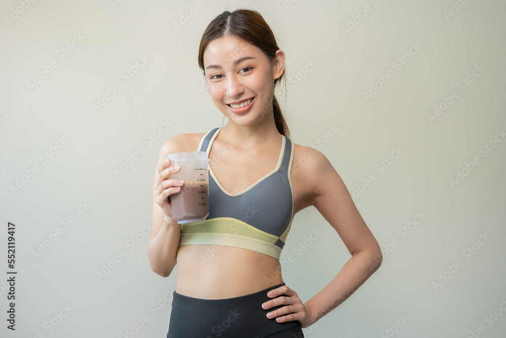 Diet meal replacement for weight loss, happy asian young woman, girl in sportswear, hand in holding protein shake bottle for drink supplement for muscle after workout at home. Healthy body care person Diet meal replacement for weight loss, happy asian young woman, girl in sportswear, hand in holding protein shake bottle for drink supplement for muscle after workout at home. Healthy body care person