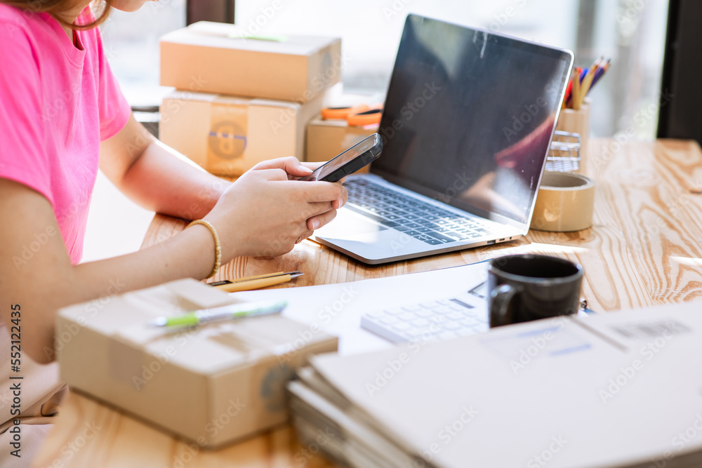 Fototapeta premium start a small business Young Asian small business owner working as a freelancer and packing boxes for deliveries to customers. order online