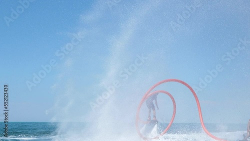 Water extreme sport. The guy is flying at the aquatic flyboard. A lot of water pressure.