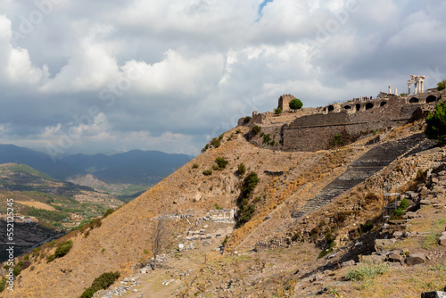 The Hellenistic threatre (2nd century BCE) of Ancient Pergamon on top of Kale Hill. Pergamon Ancient City. Scenic sky and valley at background. Bergama, Turkey (Turkiye) photo