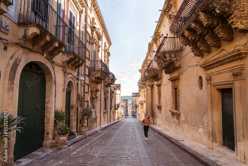 Female tourist walking between ancient buildings photo