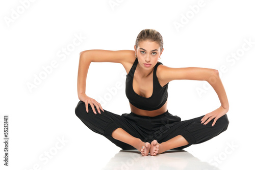 young sitting woman in sport clothes on white background