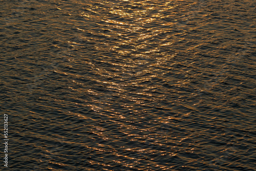Waves on the surface of the water at sunset, top view