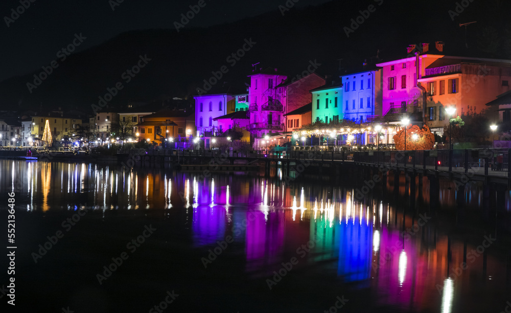 Houses illuminated by searchlights on Christmas night, by colored lights reflecting on the water of the Lake of Lugano