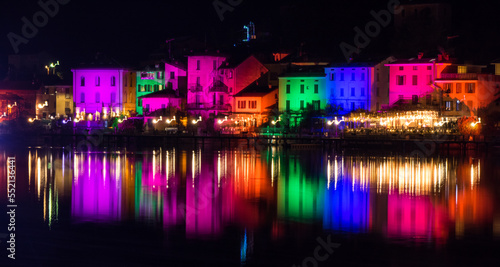 Houses illuminated by searchlights on Christmas night, by colored lights reflecting on the water of the Lake of Lugano © Alessio