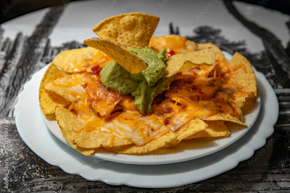 Nachos with cheese and guacamole on a plate Nachos with cheese and guacamole on a plate