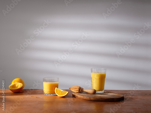 A glass of freshly pressed orange juice on the kitchen counter. Morning atmosphere, sunlight