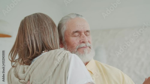 Close up elderly old couple dancing in the living room, the loving husband holds the hand of his beloved wife. Enjoy life together and feel happy. Modern apartments