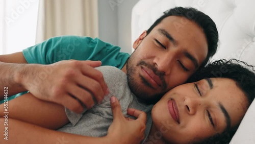 Love, morning and wake up with a black couple in bed cuddling in the bedroom of their home together. Sleeping, happy and smile with an affectionate man and woman hugging while bonding in a house