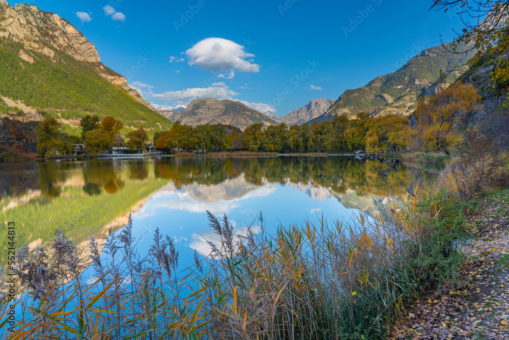Landscape in the French southern alps in the middle of a large valley in autumn with a lake 