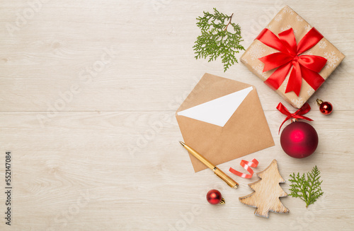 Craft envelope with christmas decoration on wooden background, top view