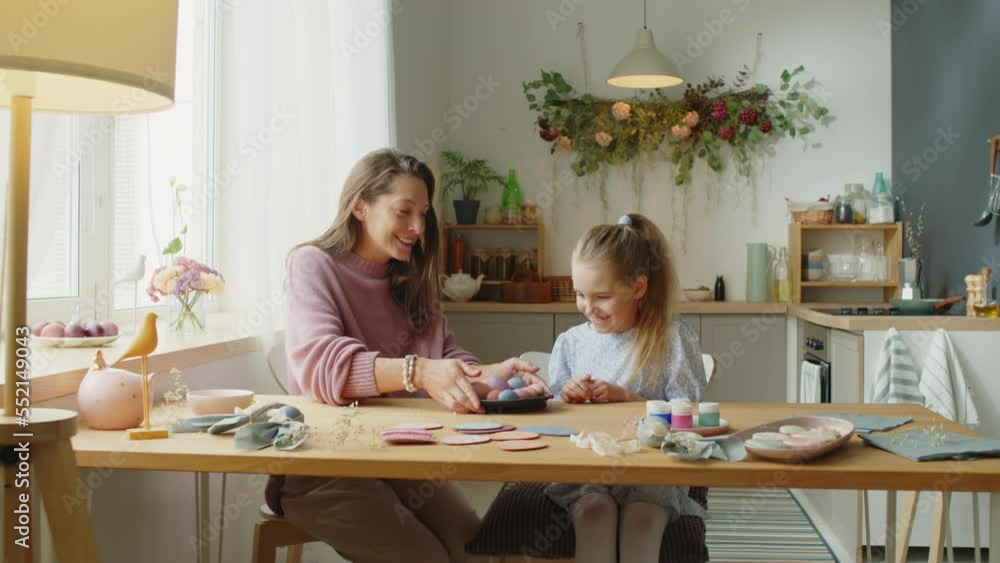 Zoom in shot of beautiful mother and cute little daughter preparing to decorate eggs for Easter day at home Zoom in shot of beautiful mother and cute little daughter preparing to decorate eggs for Easter day at home