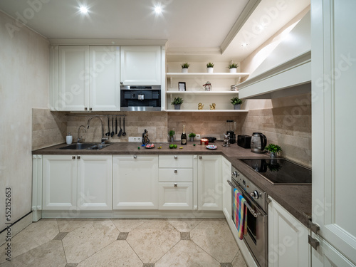 Modern interior of light kitchen in luxury apartment. Home appliances. Sink.