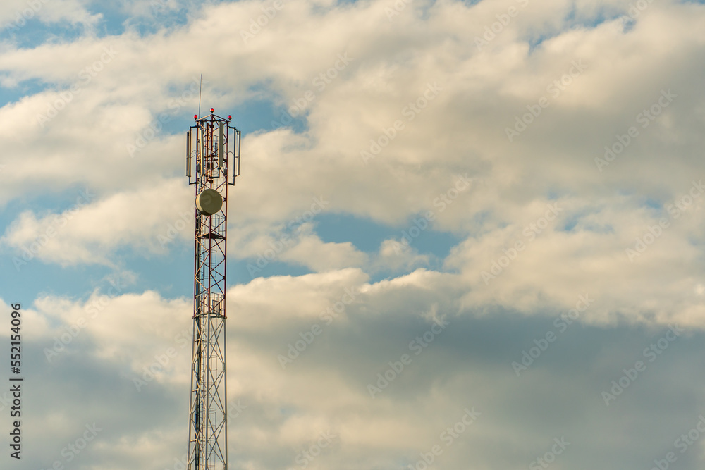 New GSM antennas on a high tower against a blue sky for transmitting a 5g signal are dangerous to health. Radiation pollution of the environment through cell towers. The threat of extinction