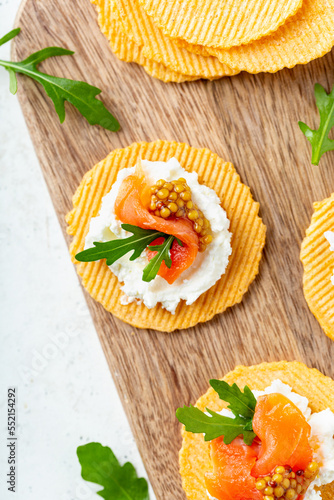 Overhead shot of a finger food appetizer made of gluten free crisps with salmon and mustard