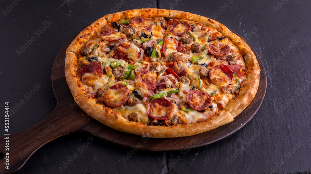 Beef Supreme pizza isolated on cutting board top view on dark background italian fast food