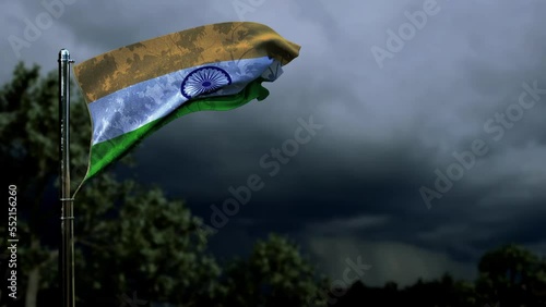 waving India flag for state holiday on dark storm clouds