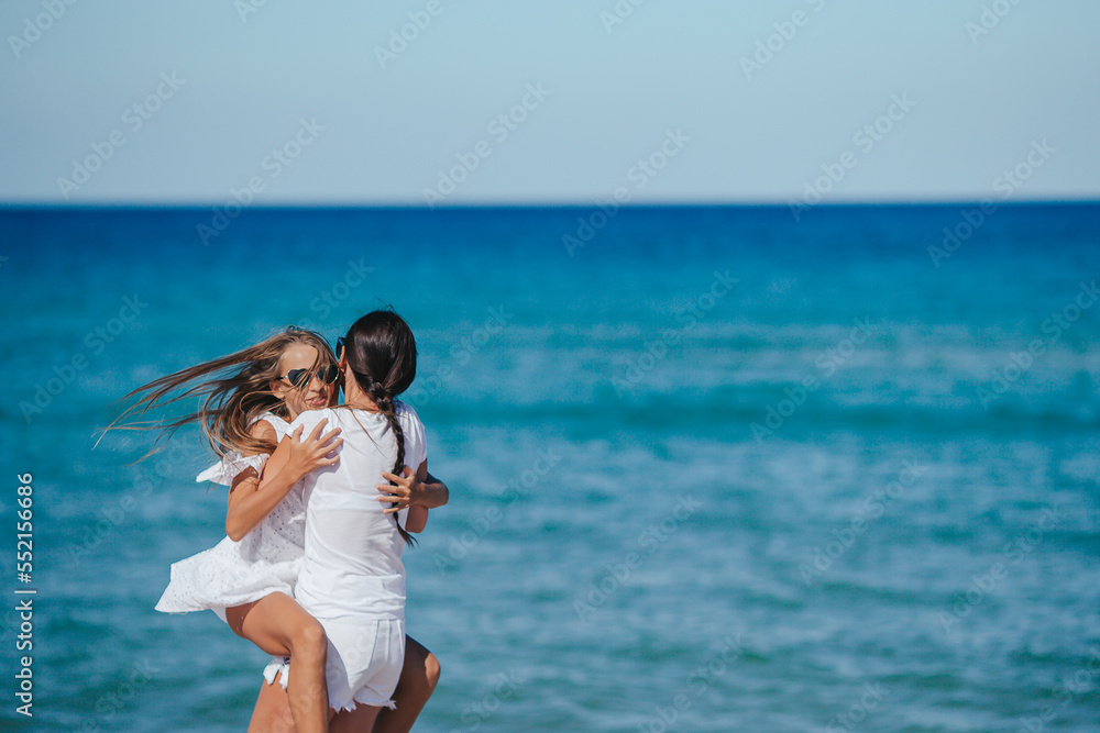 Family of mom and her adorable daughter having fun on the beach Family of mom and her adorable daughter having fun on the beach