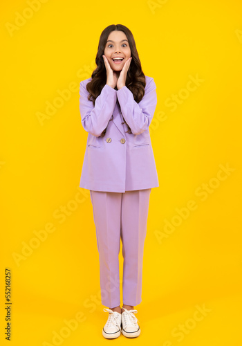 Full length of pretty cheerful teenager girl having fun good mood and posing in casual clothes isolated over yellow background. Happy teenager, positive and excited emotions of teen girl.