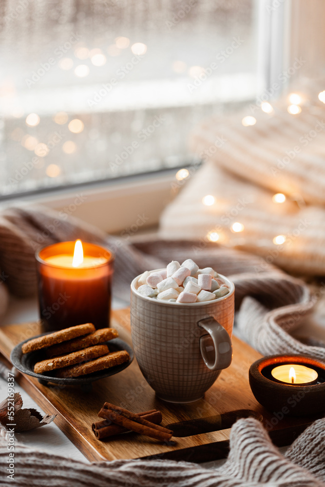 warm cozy window arrangement, winter or autumn concept, coffe, candles throw lights