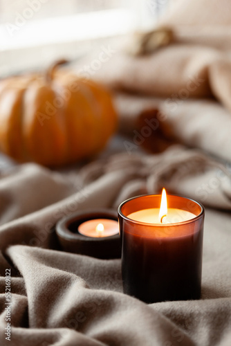 warm cozy window arrangement, winter or autumn concept, candles throw pumpkin