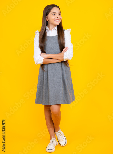 School uniform. Full length photo of pretty teenager child girl wear casual clothes isolated on yellow background.