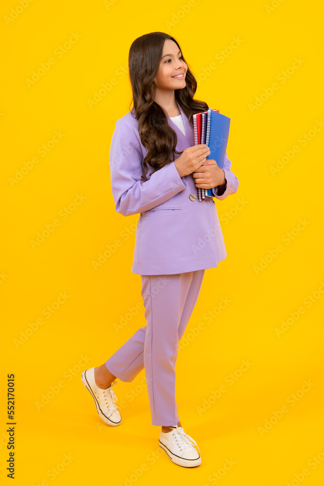 Back to school. Teenager schoolgirl with book ready to learn. School girl children on isolated yellow studio background. Back to school. Teenager schoolgirl with book ready to learn. School girl children on isolated yellow studio background.