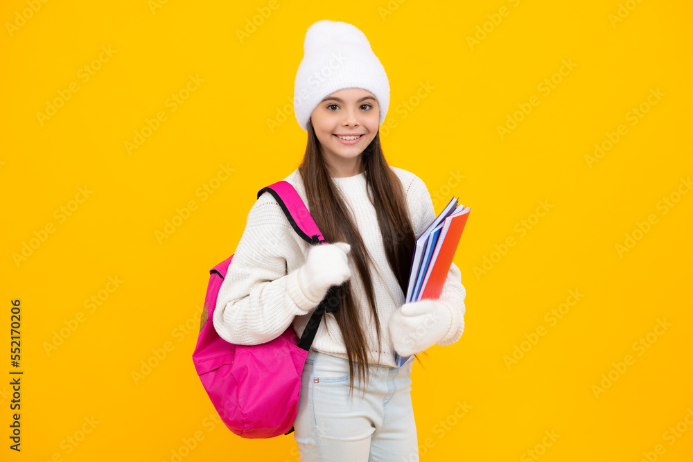 Winter school. Teenager school girl with backpack in autumn clothes on yellow isolated studio background. Winter school. Teenager school girl with backpack in autumn clothes on yellow isolated studio background.