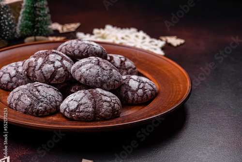 Delicious fresh brownies with Christmas decorations on a dark concrete background