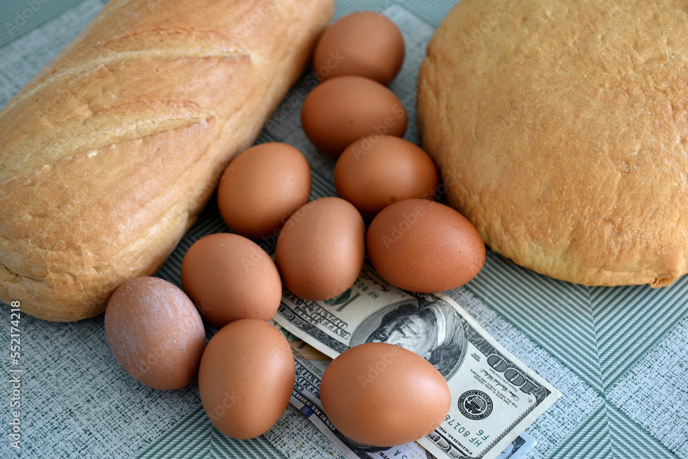 Bread, chicken eggs and money on the table. Bread, chicken eggs and money on the table.