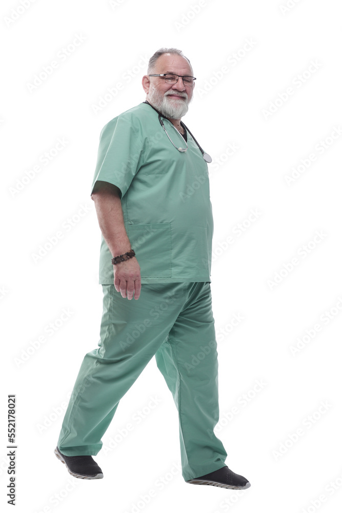 in full growth. Mature doctor with a stethoscope confidently stepping forward in full growth. Mature doctor with a stethoscope confidently stepping forward