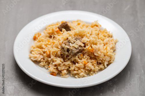 Rice with vegetables and meat on white plate