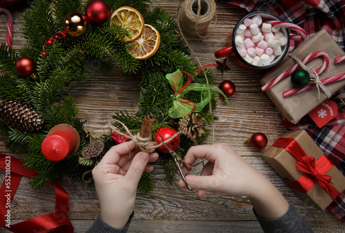 Christmas home decoration, female hands holding a wreath, hand made. Merry Christmas. Flat lay.High quality photo