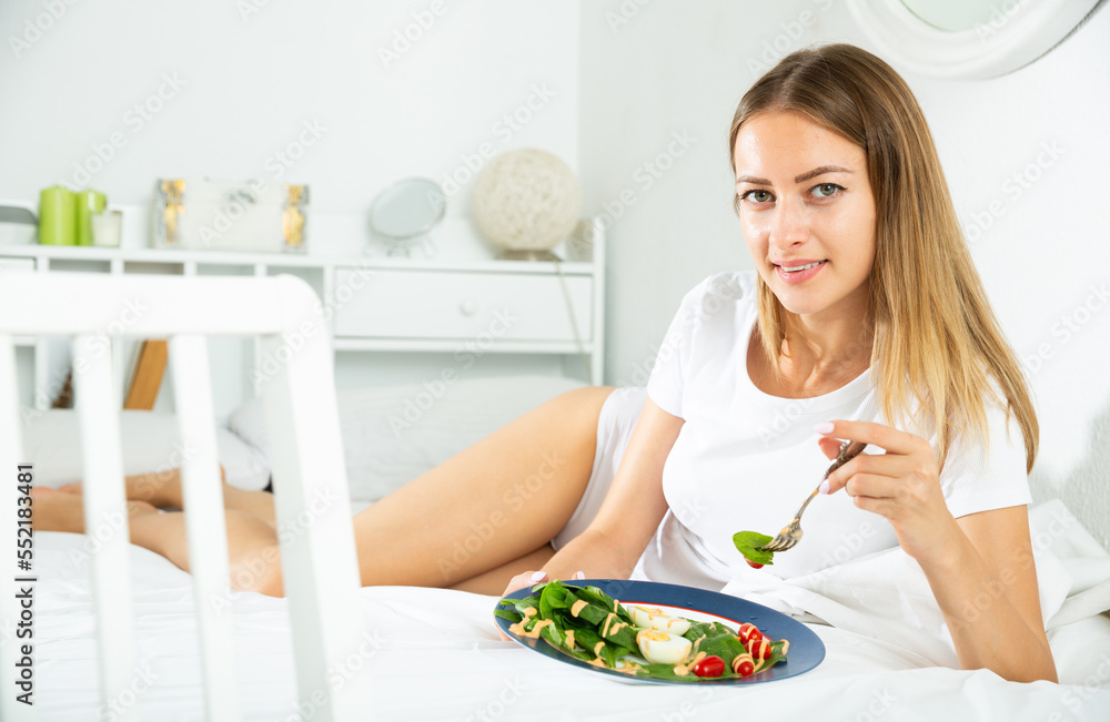 Attractive girl in underwear having healthy breakfast in her bed
