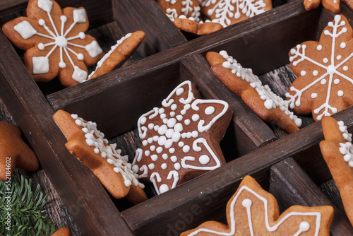 Collection of various gingerbread cookies in a box with fir branches