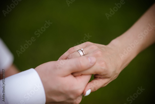 hands of bride and groom with rings. bride and groom in a cafe. wedding bouquet table. bride and groom hold each other's hands. Wedding rings. Loving couple in a cafe. hot tea for lovers © Anton