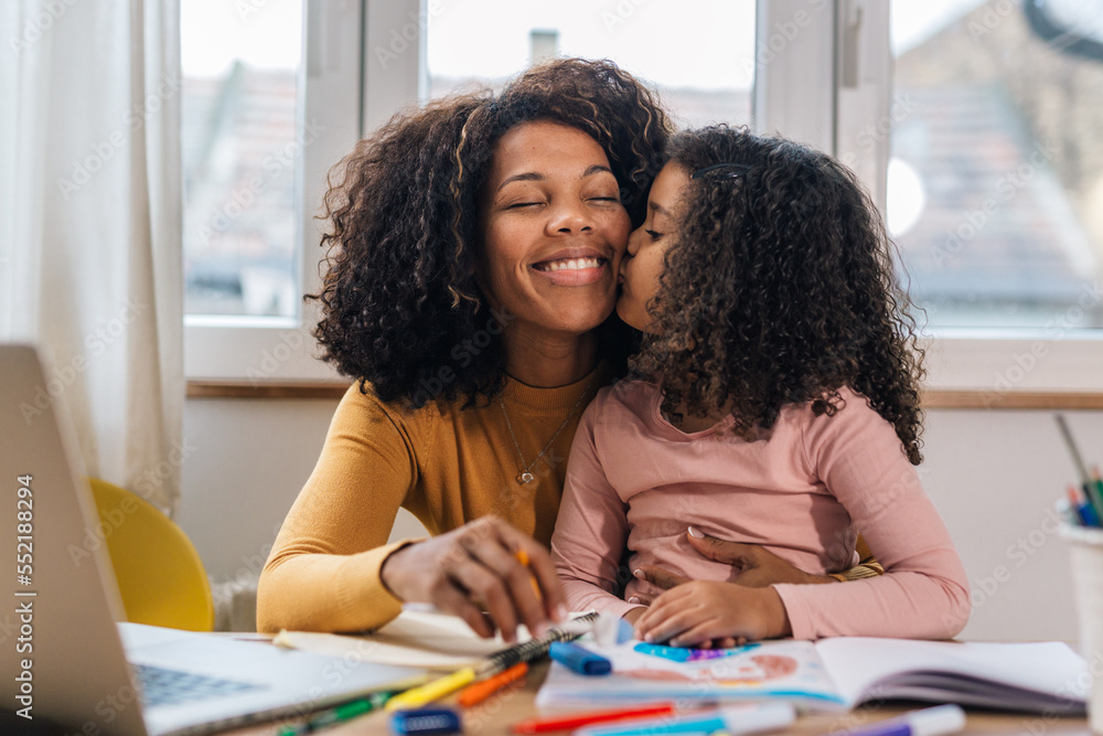 Mom and daughter working together, loving daughter kisses her mother ...