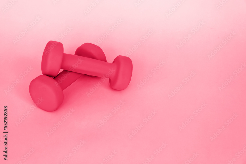 Green dumbbells for sports on a pink background. Sports, sports nutrition, healthy eating, diet. Space for the text. Green dumbbells for sports on a pink background. Sports, sports nutrition, healthy eating, diet. Space for the text.
