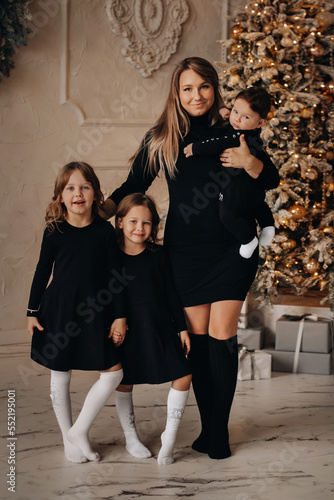 Smiling woman posing with her daughters and son on Christmas eve