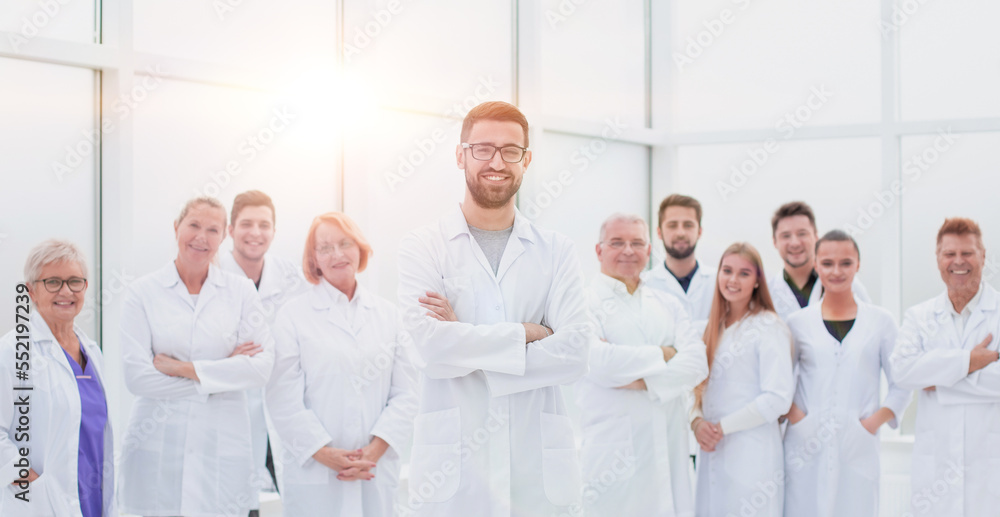 smiling research supervisor standing in front of his team.